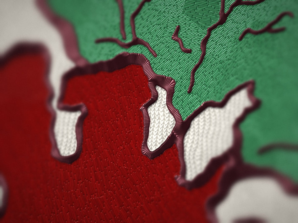 Close-up of the beet embroidery: raised satin stitching and a dark outline against white knit